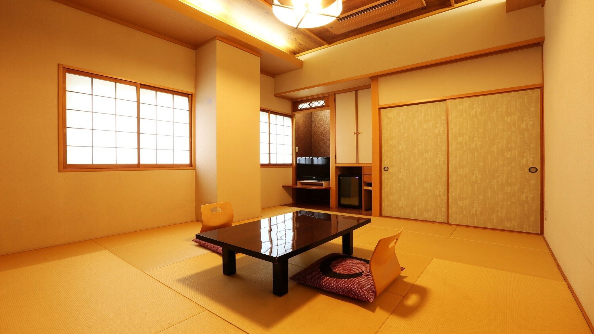 A traditional Japanese room with tatami flooring, a low table, and sliding doors.