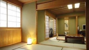 A traditional Japanese room with tatami flooring, sliding doors, and a low wooden ceiling. - Arima Royal Hotel (Kobe)
