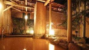 A traditional Japanese onsen with wooden beams, stone walls, and a wooden floor. - Arima Royal Hotel (Kobe)