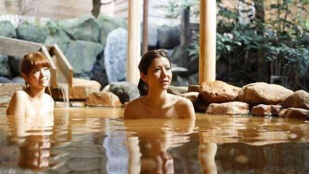 A hot spring bath area with large rocks and wooden structures. - Arima Royal Hotel (Kobe)