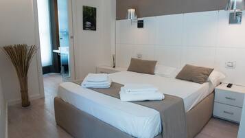 Une chambre à coucher moderne avec un grand lit, des tables de chevet et une petite table de nuit.