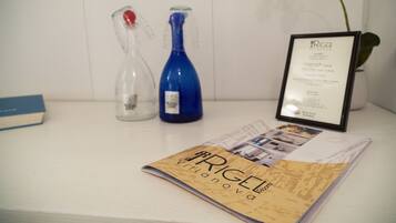 A magazine titled "RIGEL Villanova" on a table with a framed menu and two glass bottles.