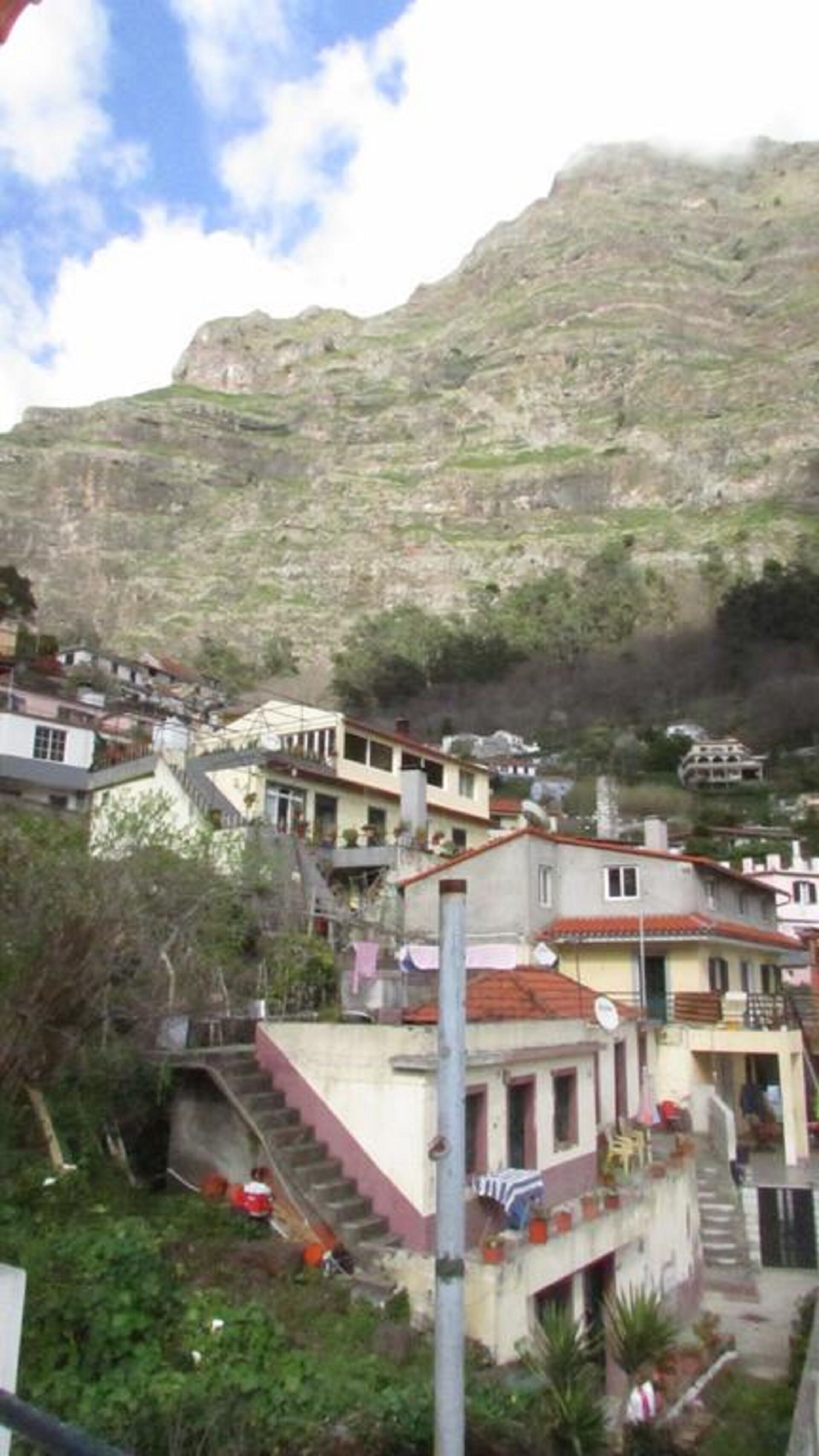 Un barrio residencial en una ladera con casas que tienen balcones y una escalera que conduce a los edificios.