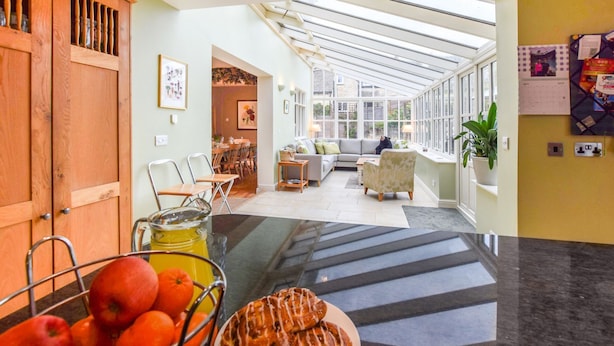 A spacious room with a large glass ceiling, a dining area, and a seating area with a sofa and chairs. - Barebones Farm - sleeps 14 guests  in 7 bedrooms (Winchcombe)
