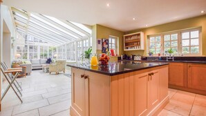 A spacious kitchen with a large island, ample natural light from skylights, and a view of the outdoors. - Barebones Farm - sleeps 14 guests  in 7 bedrooms (Winchcombe)