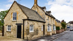 A row of stone houses with pitched roofs, a paved street, and parked cars. - Barebones Farm - sleeps 14 guests  in 7 bedrooms (Winchcombe)