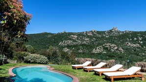 A pool with lounge chairs and a mountainous backdrop. - Porto Cervo Villa La Gjanda, surrounded by nature, private heated pool (Arzachena)