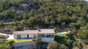 A house with a tiled roof, a swimming pool, and a view of a forested hillside. - Porto Cervo Villa La Gjanda, surrounded by nature, private heated pool (Arzachena)