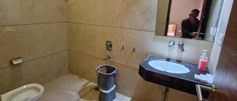 Een badkamer met toilet, bidet en wastafel.
