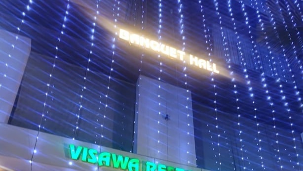 The exterior of Visawa Restaurant with a modern design, featuring a prominent illuminated sign and decorative string lights. - Visawa Palace Nanded (Nanded)