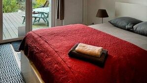 A bedroom with a bed, a clock on the wall, and a view of the outdoors through a sliding door. - Budget Room Brussels (Brussels)