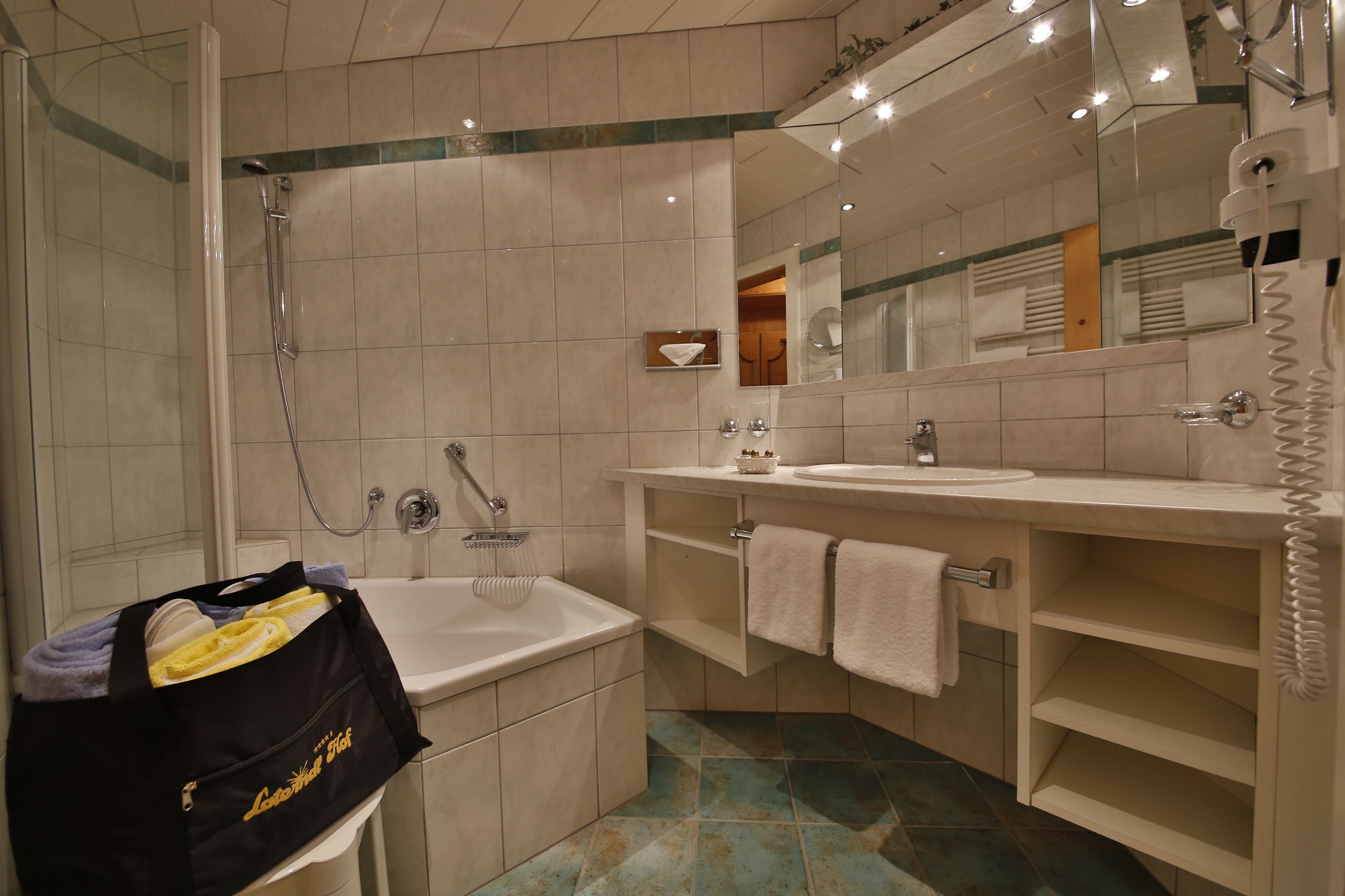 Ein Badezimmer mit Badewanne, Dusche, Waschbecken und Spiegel.