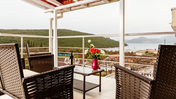 A balcony with wicker chairs and a table, overlooking a scenic landscape with hills and a body of water. - Exclusive 3 bedrooms split level sea-views apartment overlooking Bigova Bay (Bigova)