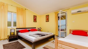 A bedroom with a large bed, a smaller bed, a nightstand, a dresser, and a window with curtains. - Exclusive 3 bedrooms split level sea-views apartment overlooking Bigova Bay (Bigova)