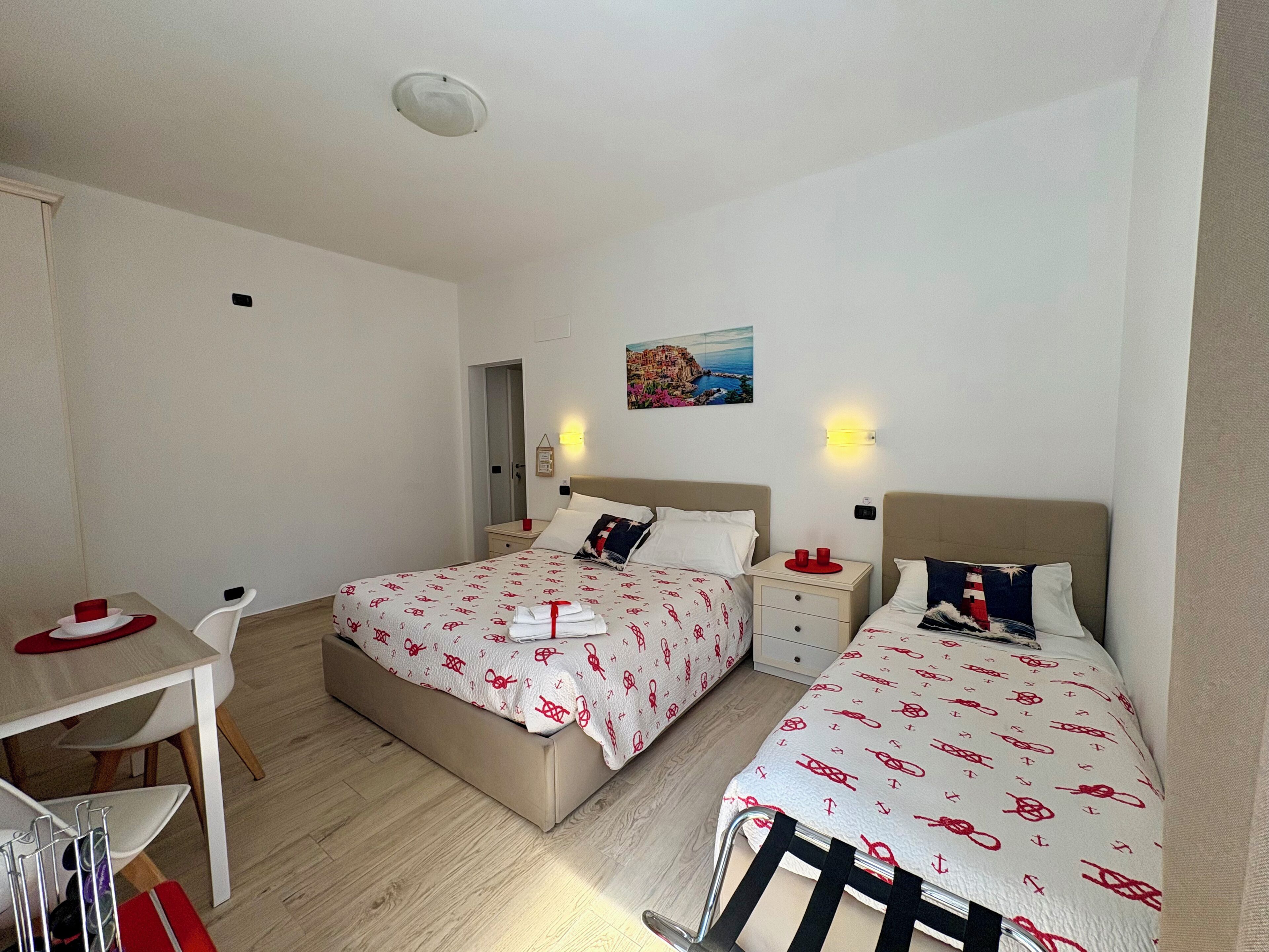 Habitació d'hotel amb dos llits, un escriptori i una cadira.
