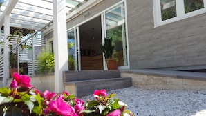 Une maison moderne dotée d’un porche abrité, d’un escalier et d’une plante en pot.