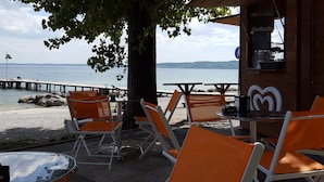 Un restaurant en bord de mer, doté d’une terrasse, offrant une vue sur la mer et abrité dans un bâtiment en bois avec une enseigne.
