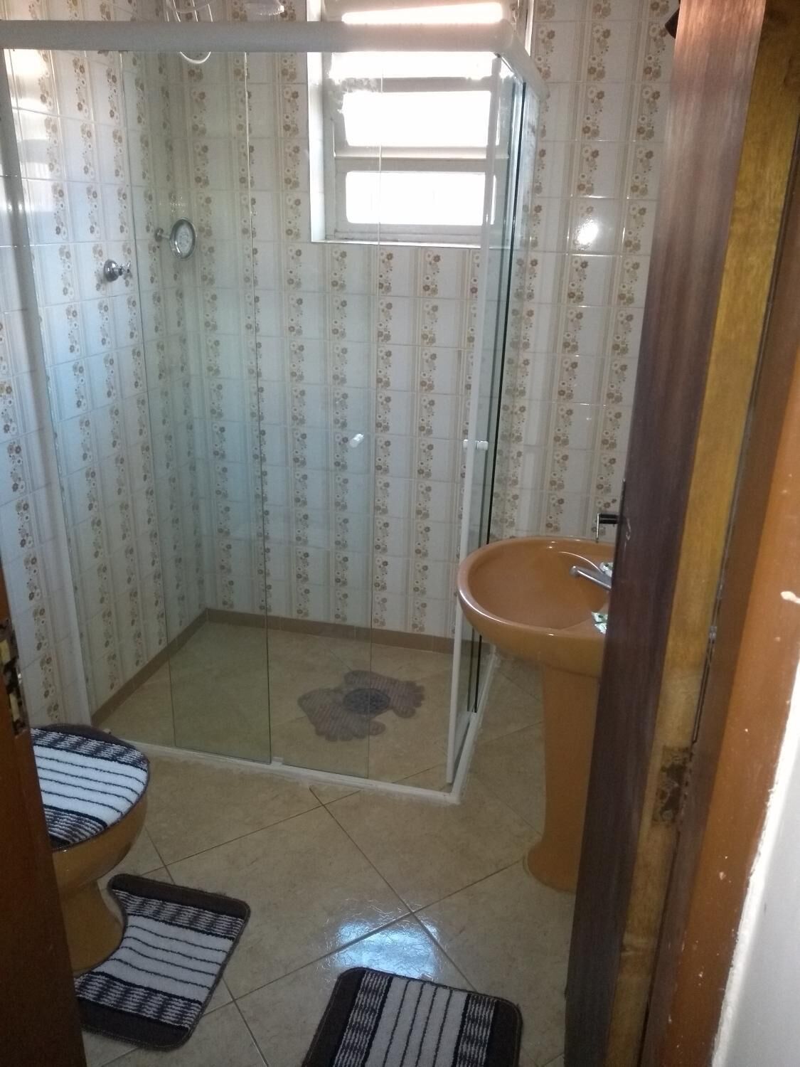 A bathroom with a shower, toilet, and sink.