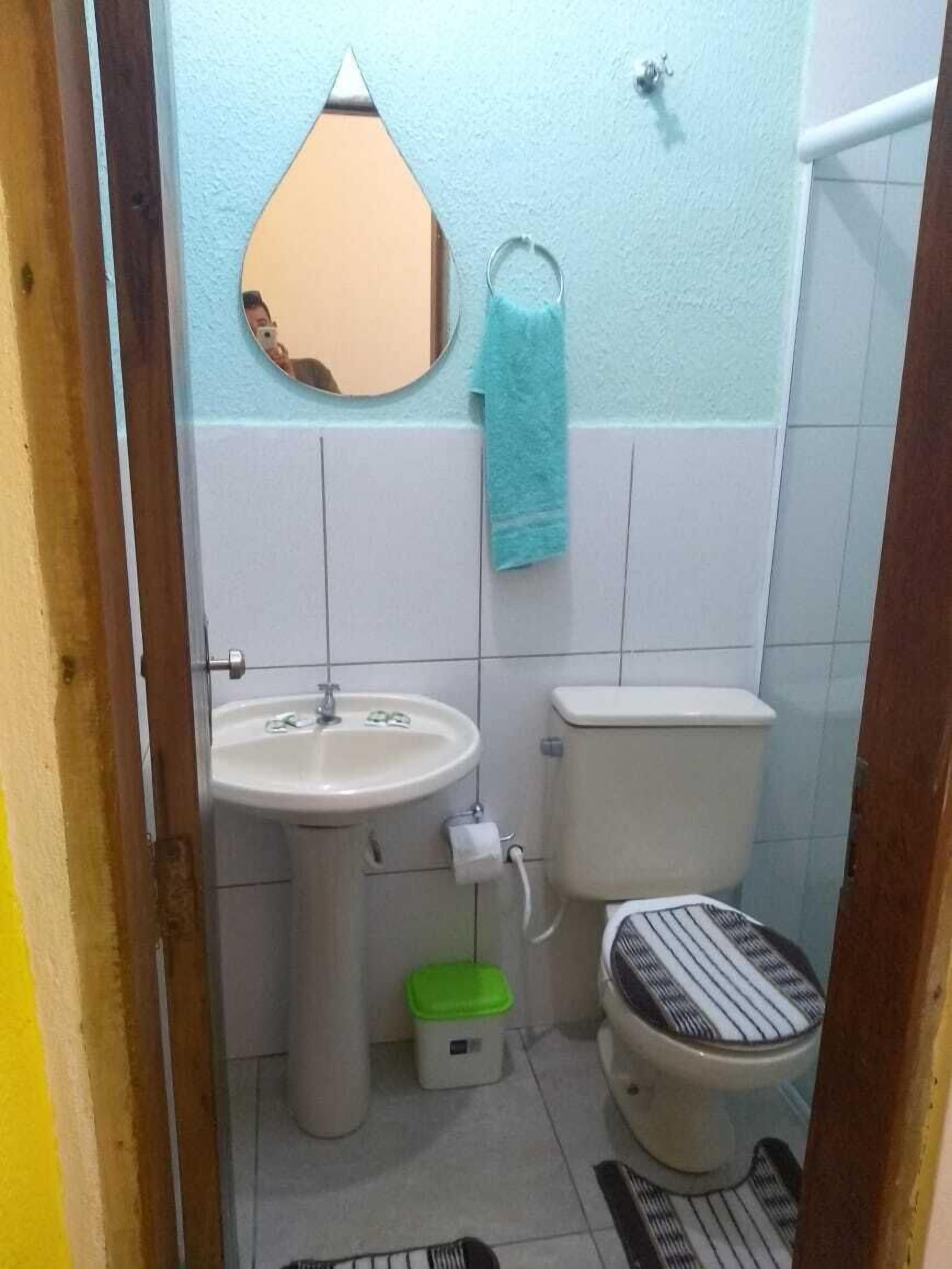 Uma casa de banho pequena com lavatório, sanita e espelho.
