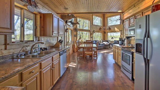 Una cocina amplia con armarios de madera, una isla grande y un comedor con mesa y sillas.