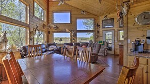 Un interior espacioso de madera con ventanas amplias, un comedor y una cocina.