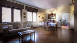 Ein Wohnzimmer mit einer Couch, einem Couchtisch und einem Essbereich mit Stühlen und einem Tisch.