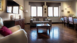 Ein Wohnzimmer mit einer Couch, einem Couchtisch und einem Essbereich mit Stühlen und einem Tisch.