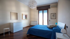 Ein Schlafzimmer mit einem Bett, einem Schminktisch und einem kleinen Tisch.