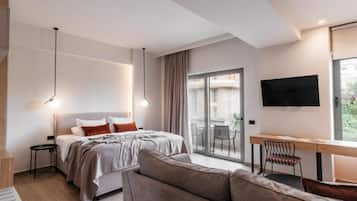 A modern bedroom with a bed, a desk, and a television.