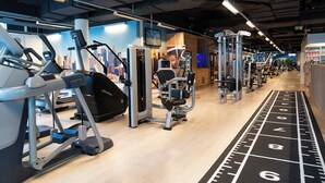 A gym with treadmills, weight machines, and a running track. - Clarion Hotel Vienna South (Vienna)