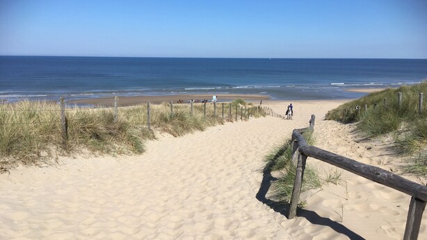 A sandy beach path leading to the ocean with a wooden fence on the right. - Bungelow "Duinvogel" Beach with bath in the garden (Noordwijk)