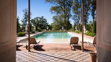 Una piscina al aire libre de temporada, sombrillas