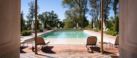 Una piscina al aire libre de temporada, sombrillas