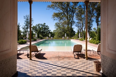 Una piscina al aire libre de temporada, sombrillas
