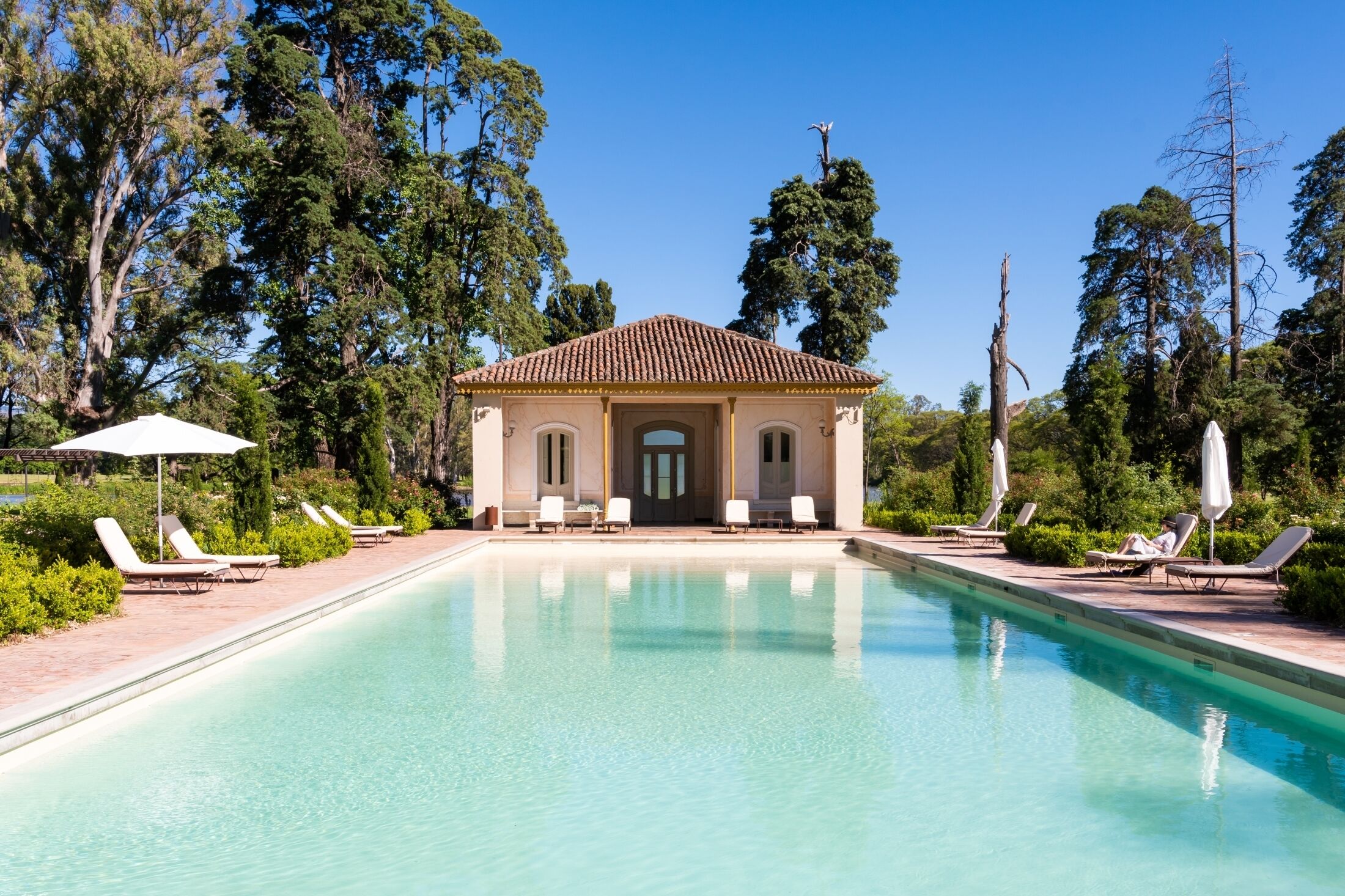 Una piscina al aire libre de temporada, sombrillas