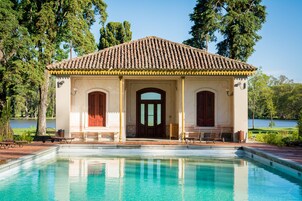 Un edificio con techo de tejas, piscina y vista al lago.