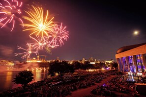 A large outdoor venue with a crowd, a body of water, and a building with a dome and large windows. - Holiday Inn Express & Suites Downtown Ottawa East by IHG (Ottawa)