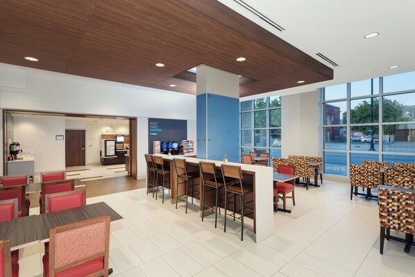 A modern cafe with a bar area, seating, and a view of the street. - Holiday Inn Express & Suites Downtown Ottawa East by IHG (Ottawa)