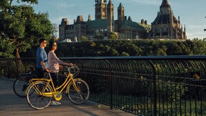 A couple on a bridge with a historic building in the background. - Holiday Inn Express & Suites Downtown Ottawa East by IHG (Ottawa)