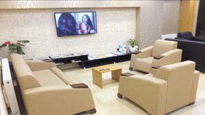 A modern lobby with beige sofas, a coffee table, and a flat-screen TV mounted on the wall. - Basoglu Bulancak Otel (Bulancak)