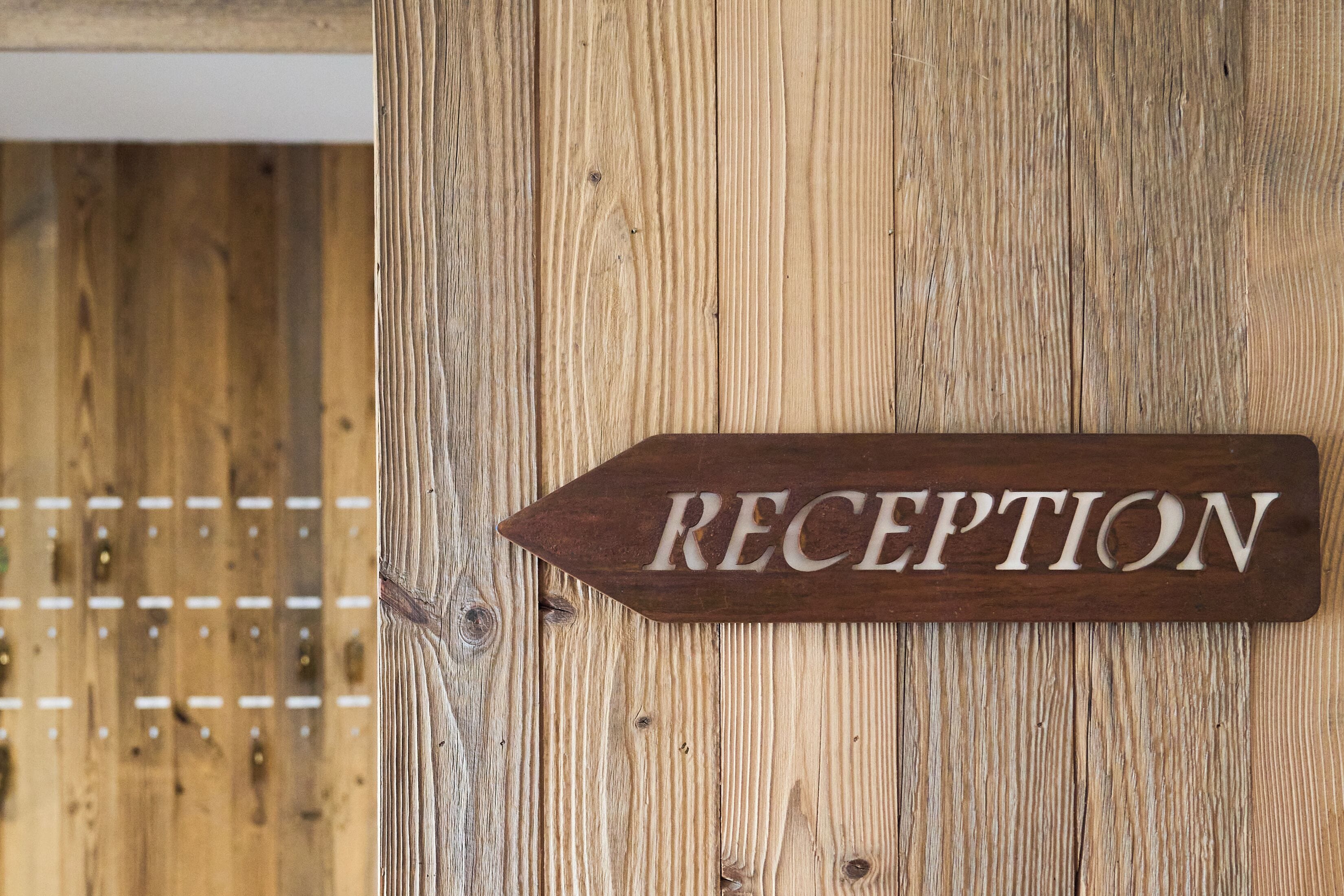 A wooden reception sign on a wall.
