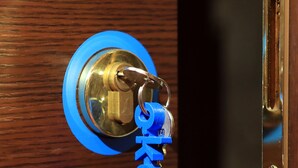 A blue keychain with the word "key" attached to a keyhole. - Bari Primo Piano (Bari)