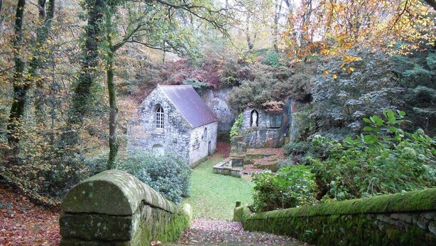A stone building with a slate roof, surrounded by a well-maintained garden and a stone wall. - ---------Chestnut - La Châtaigne----------- (Langoëlan)