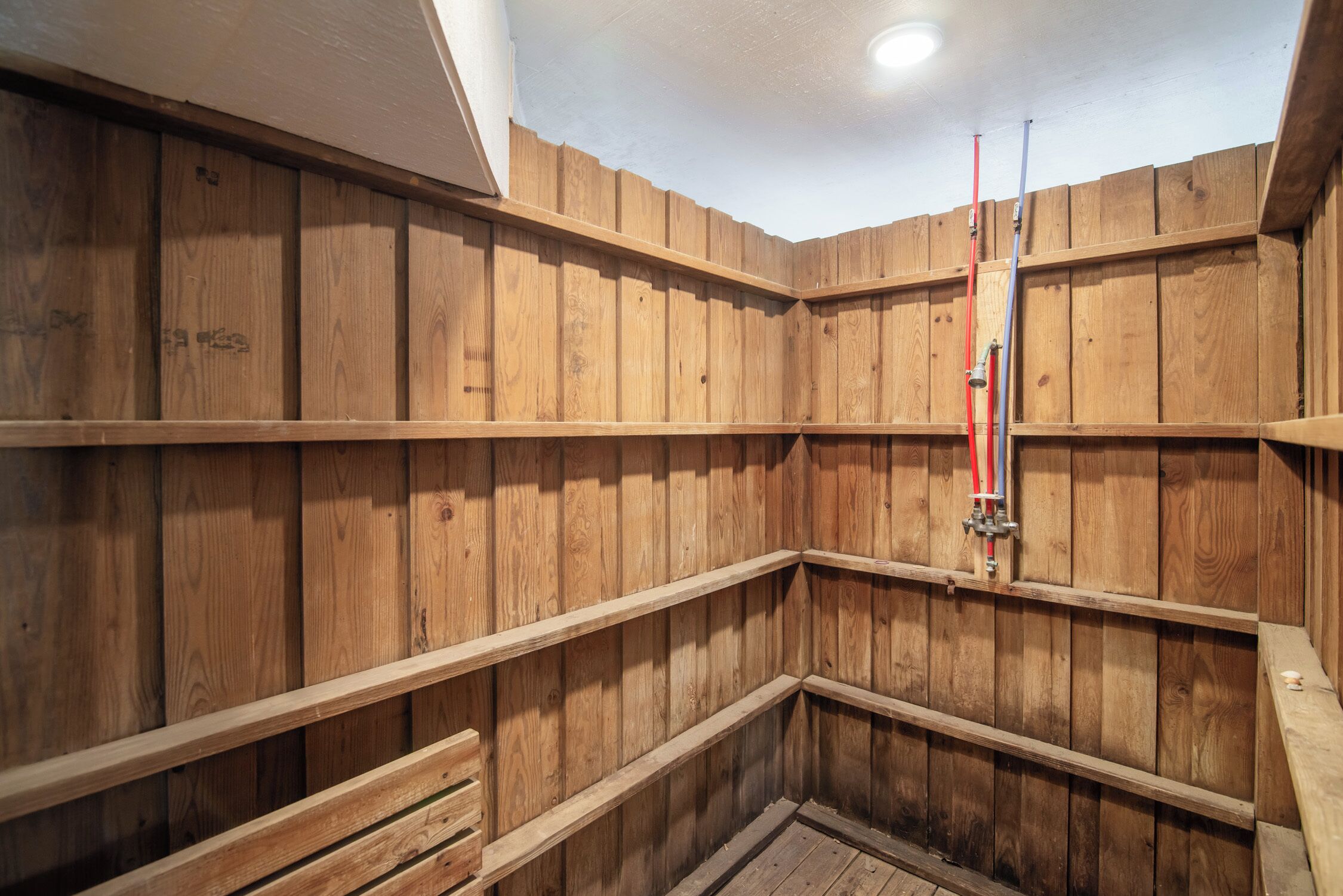 Un intérieur en bois avec des étagères intégrées et un espace douche.