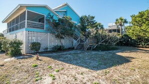 A two-story house with a balcony, a wooden deck, and a fenced yard.