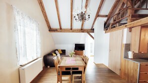 A dining area with a wooden table, chairs, and a chandelier. - Alte Kass Hotel und Kaffeehaus (Neidlingen)