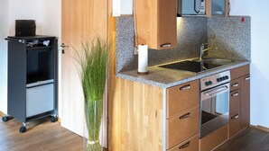 A kitchen with wooden beams, a microwave, a sink, and a stove. - Alte Kass Hotel und Kaffeehaus (Neidlingen)