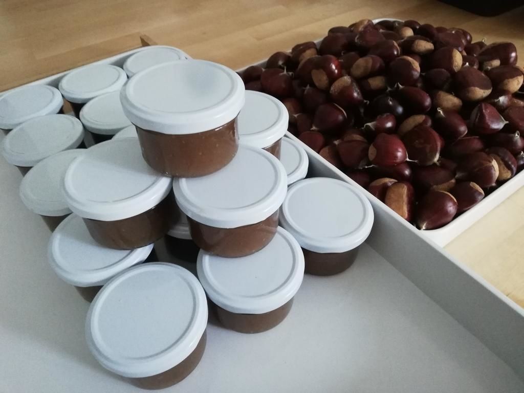 A collection of jars with lids and chestnuts.