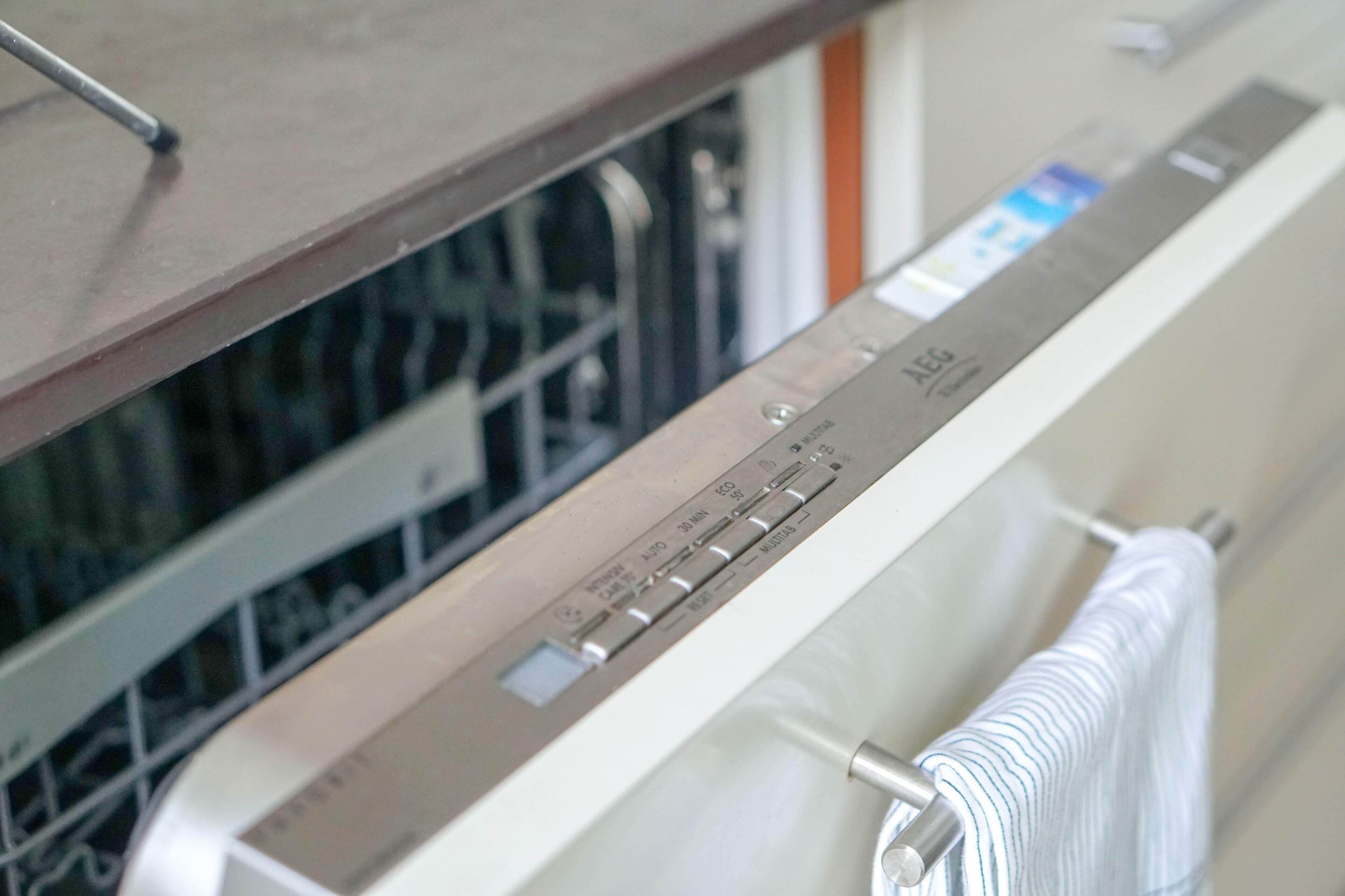 A modern kitchen with a stainless steel dishwasher and a towel rack.