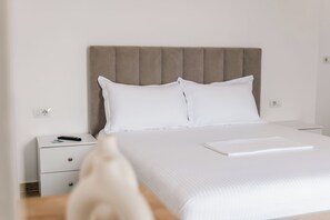 A hotel room with a bed, a nightstand, and a remote control. - Vila Malo (Ksamil)
